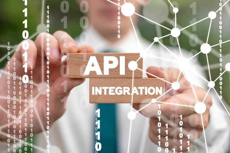 api integration concept. hands holding 2 wooden blocks. one says API the other Integration